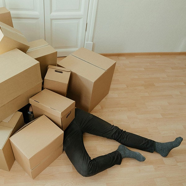 accident domestique, un homme sous une pile de cartons allongé sur le sol