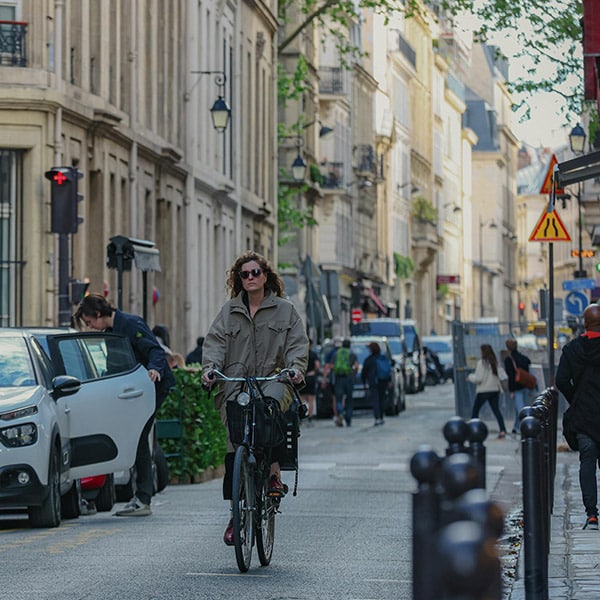 une cycliste à vélo dans une rue de Paris